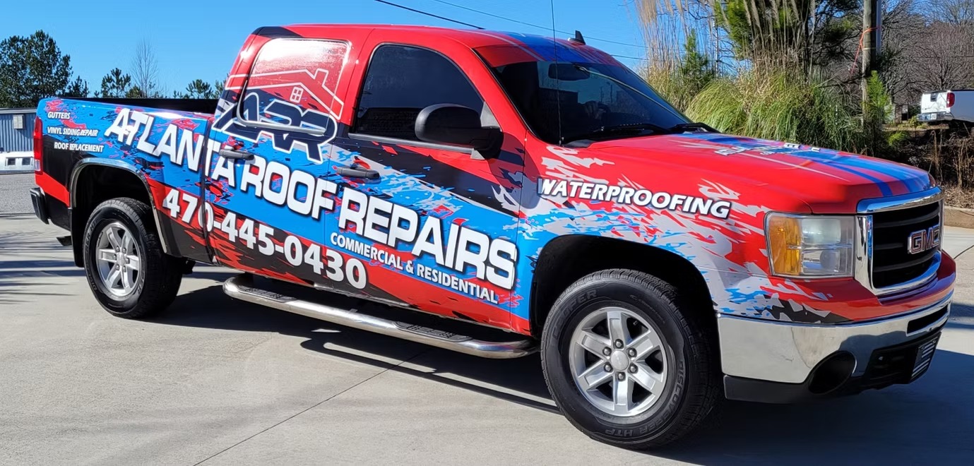 Atlanta Roof Repairs pickup with red, blue, and white vehicle graphics