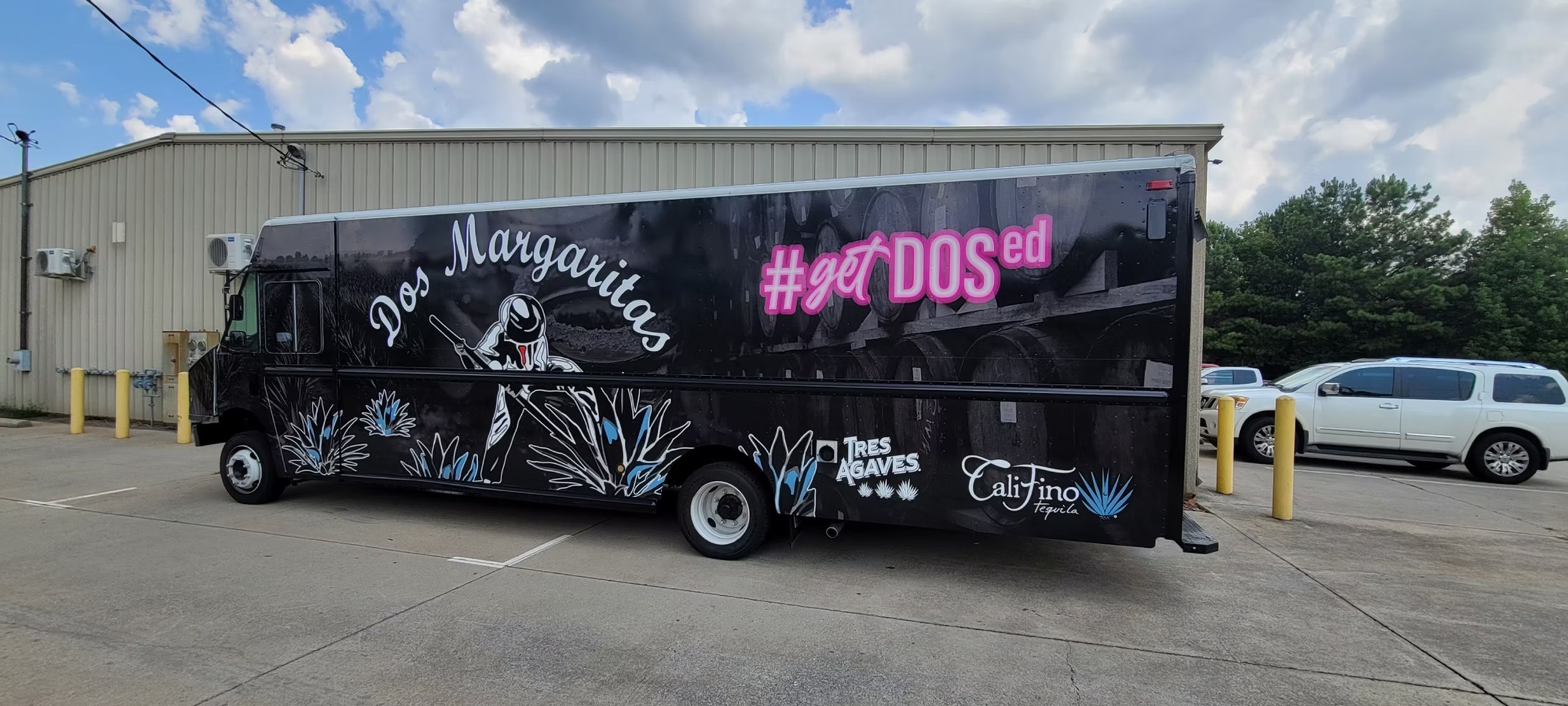 Dos Margaritas truck with pink lettering and agave illustrations on a black wrap